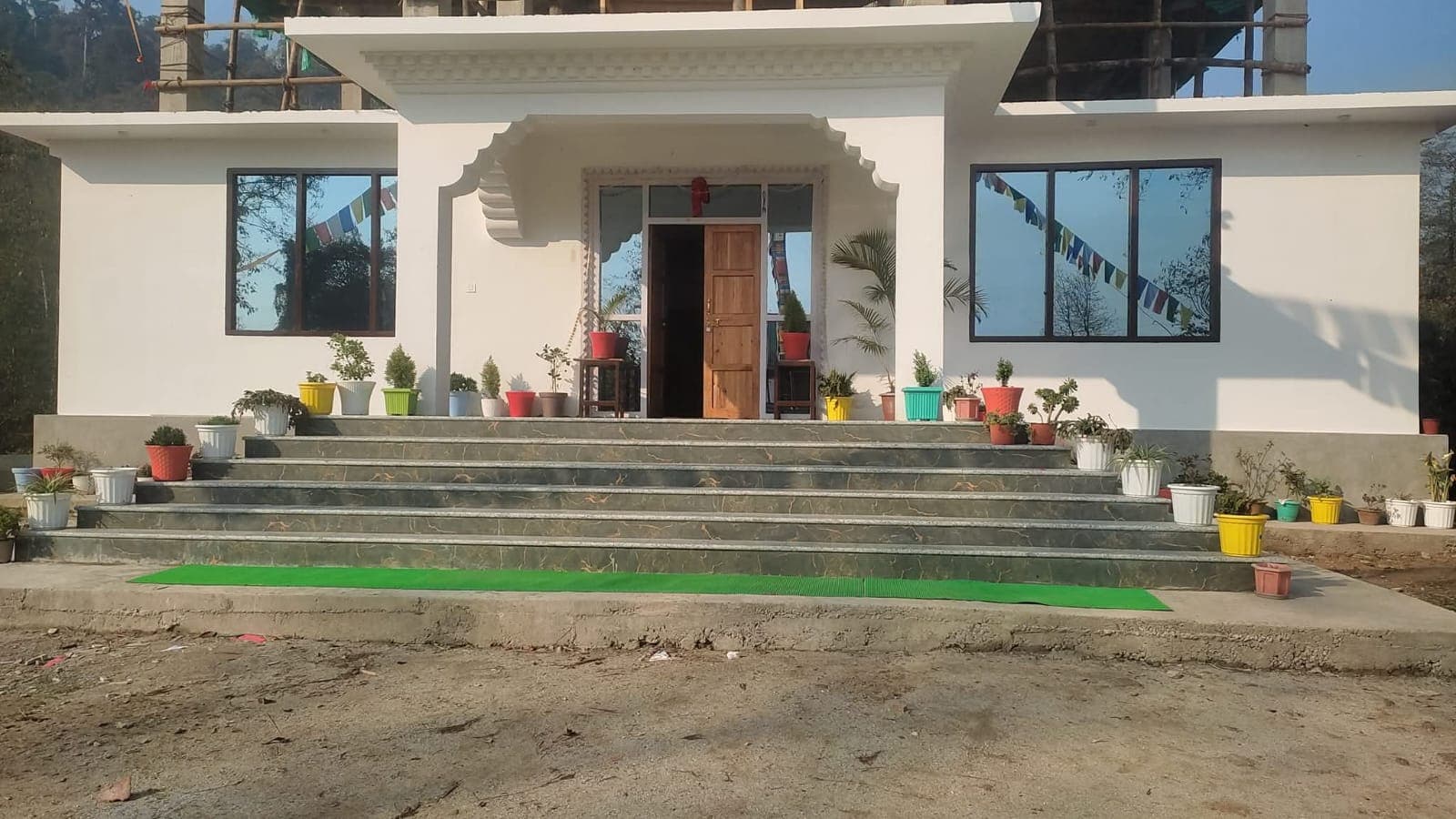 Norbukhang Homestay exterior with prayer flags