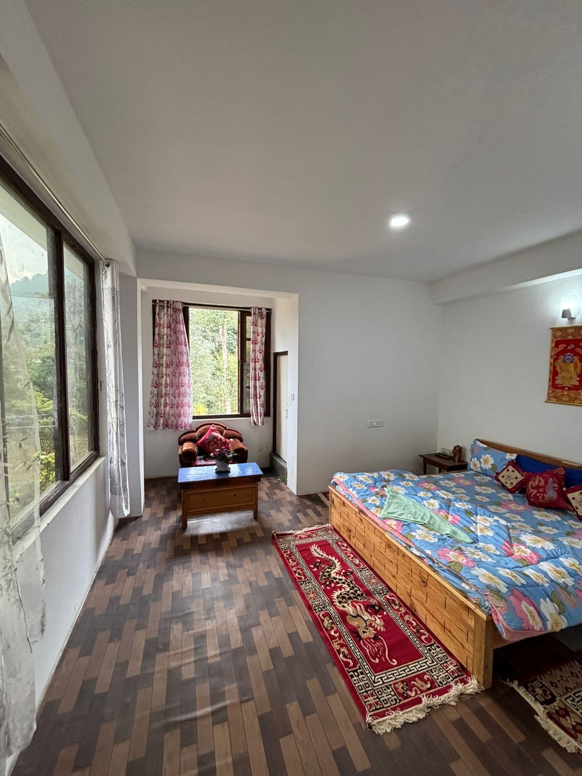 Spacious bedroom with floral bedspread and sitting area